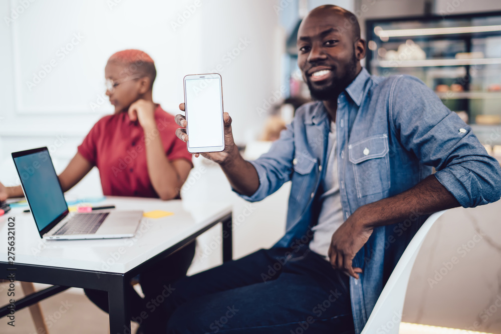 Black man showing smartphone to camera Black man showing smartphone to camera