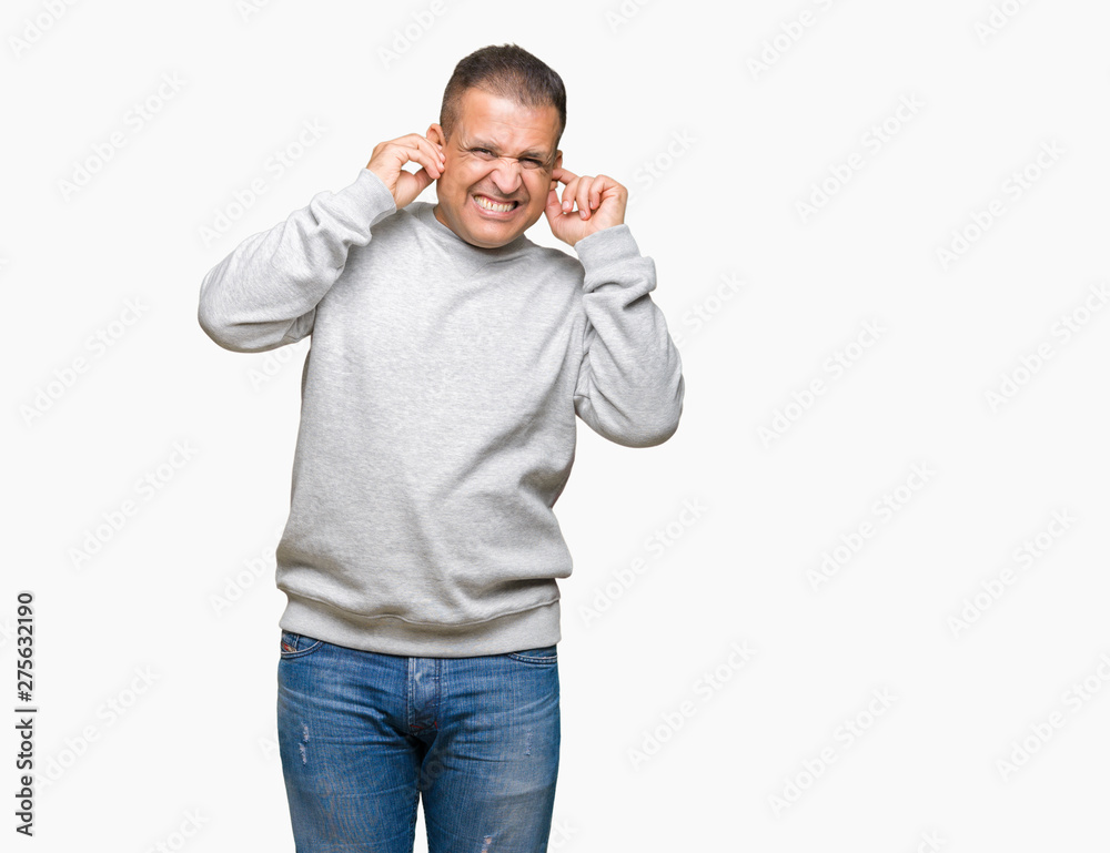 Middle age arab man wearing sport sweatshirt over isolated background covering ears with fingers with annoyed expression for the noise of loud music. Deaf concept. Middle age arab man wearing sport sweatshirt over isolated background covering ears with fingers with annoyed expression for the noise of loud music. Deaf concept.