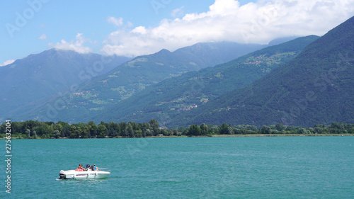 boat on the lake iseo in italy with huge mountains in the background