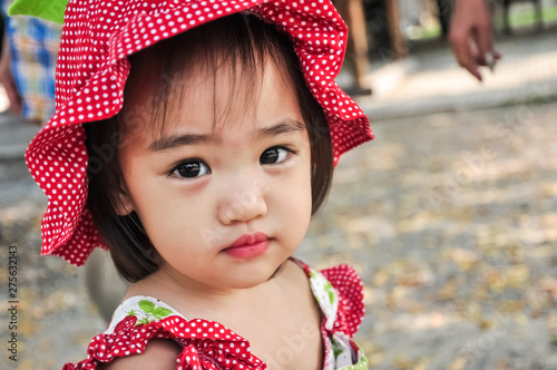 Outdoor Portrait of Little asian girl Wearing red hat