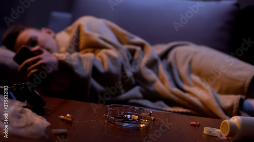 Photos Nicotine addicted teenager covered with blanket scrolling phone, feeling cold