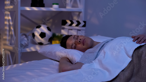 Принти на полотні Handsome male teenager sleeping peacefully early in morning, promising boy