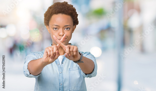 Young beautiful african american woman over isolated background Rejection expression crossing fingers doing negative sign