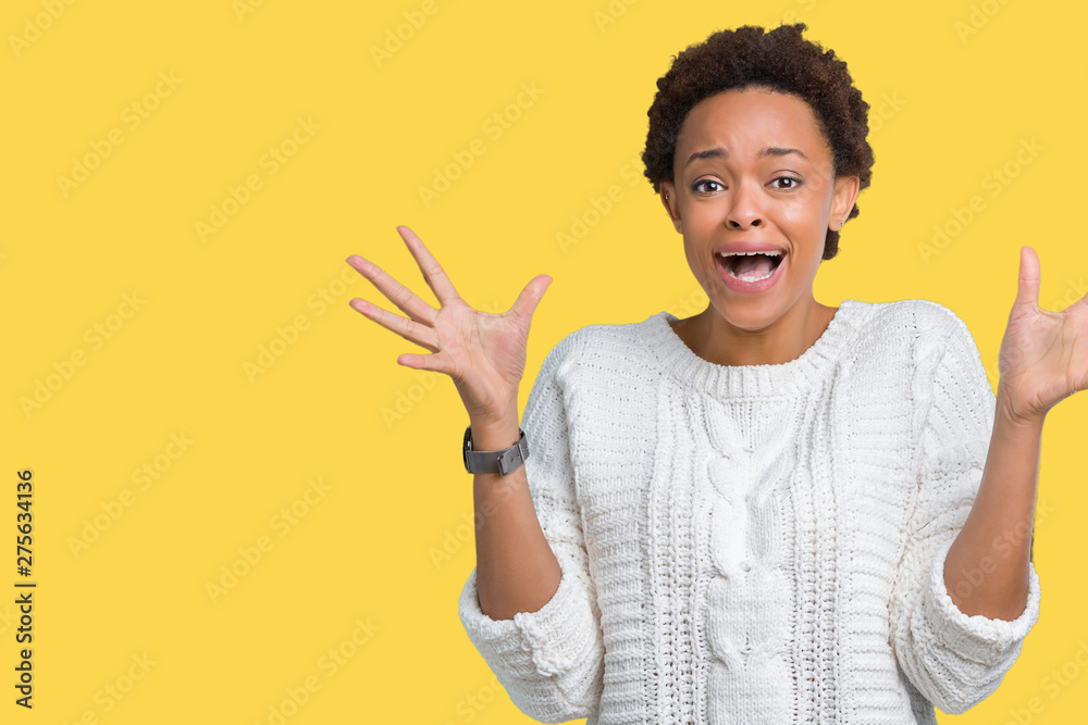 Beautiful young african american woman wearing sweater over isolated background celebrating crazy and amazed for success with arms raised and open eyes screaming excited. Winner concept Beautiful young african american woman wearing sweater over isolated background celebrating crazy and amazed for success with arms raised and open eyes screaming excited. Winner concept