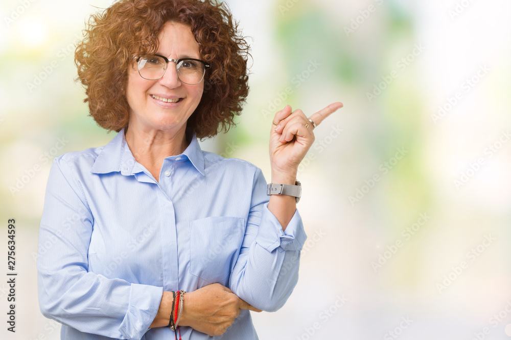Beautiful middle ager senior businees woman wearing glasses over isolated background with a big smile on face, pointing with hand and finger to the side looking at the camera. Beautiful middle ager senior businees woman wearing glasses over isolated background with a big smile on face, pointing with hand and finger to the side looking at the camera.