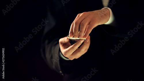 Professional illusionist getting card from deck, magic trick show, hands closeup