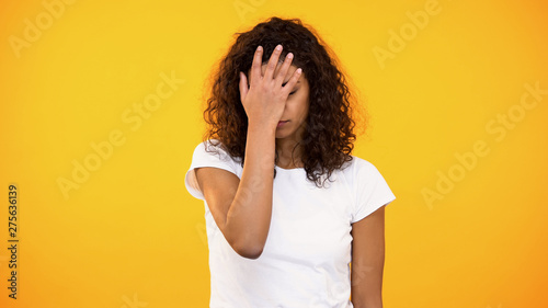 Discontent biracial lady gesturing face palm on camera against yellow background photo