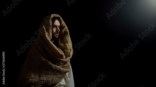 Jesus in robe standing in dark, religion as hope for salvation in sinful world