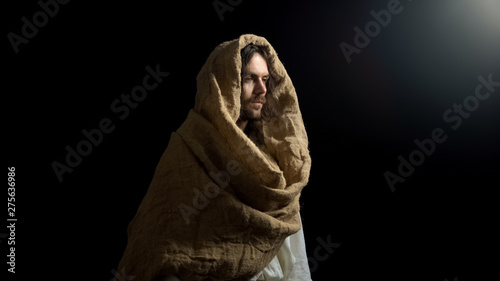 Photography Messiah in robe standing in dark, religion as hope for salvation in sinful world