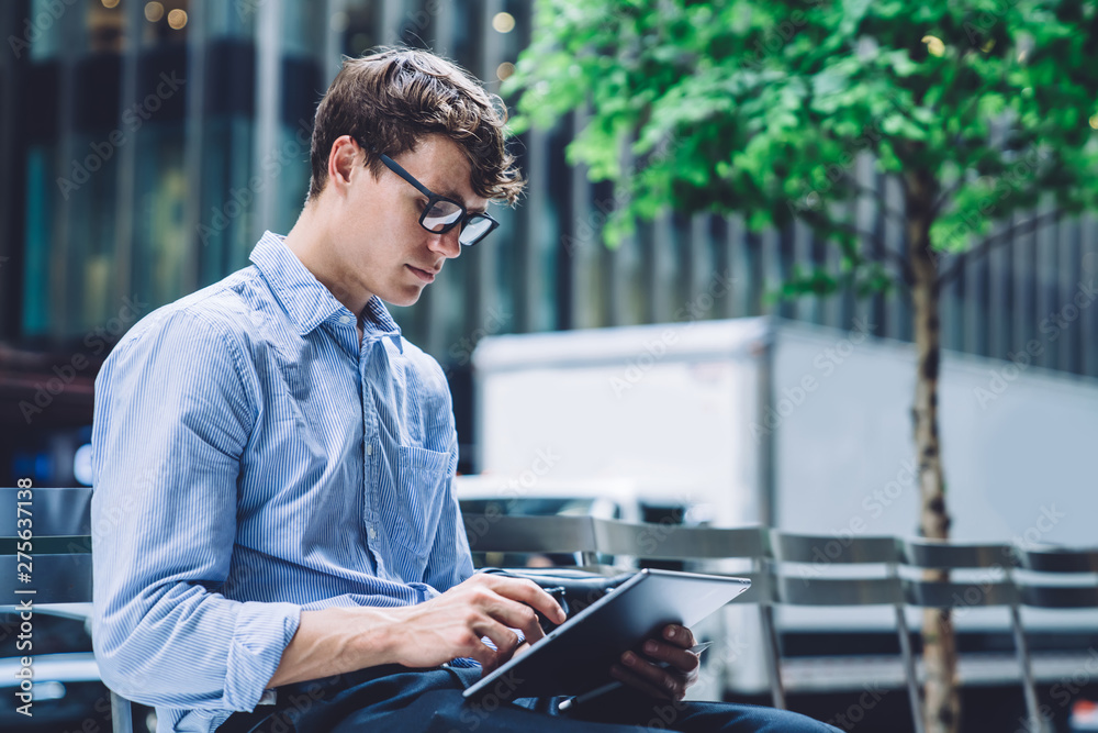 Formally dressed trader checking money transfer information on financial website connected to 4g internet on digital tablet, man in spectacles for provide eyes protection chatting with investors Formally dressed trader checking money transfer information on financial website connected to 4g internet on digital tablet, man in spectacles for provide eyes protection chatting with investors