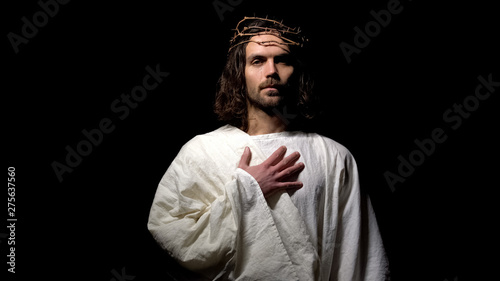 Christian prophet in crown of thorns crying, put hand on chest asking for mercy