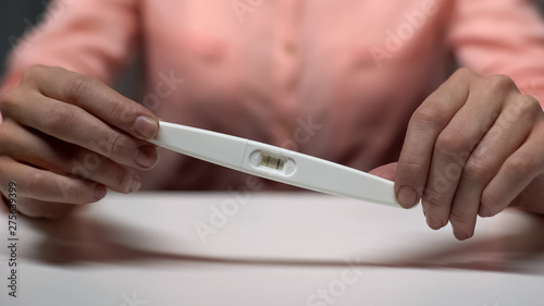 Female holding positive pregnancy test in hands  family planning  decision