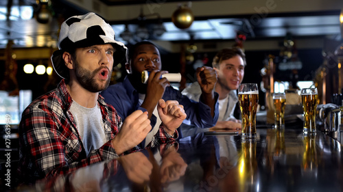 Male soccer fans watching tournament in bar expecting scoring goal, championship