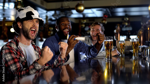 Cheerful football fans supporting favorite team in pub happy about victory, rest