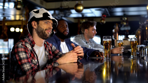 Displeased soccer team supporters watching match in pub, missing goal, game loss