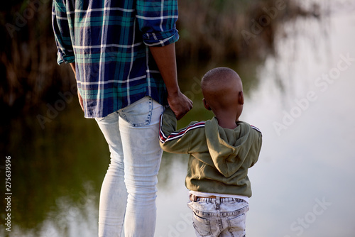 Tableau sur toile Father and son child holding hands backview
