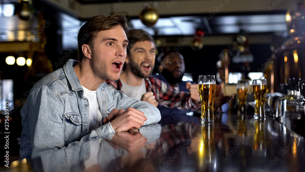 Male friend watching tournament in pub, cheering for victory of national team