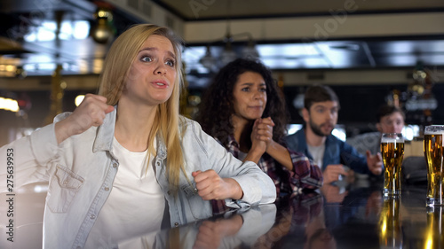 Blond lady cheering for favorite team, hanging out in pub with friends, support