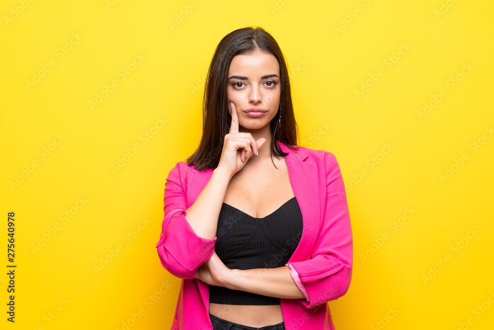 Young woman over isolated yellow background Looking front Young woman over isolated yellow background Looking front