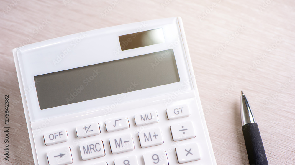 White calculator and pen on bright wooden table, analytics and statistics of financial profit, investment risk concept, copy space, top view flat lay White calculator and pen on bright wooden table, analytics and statistics of financial profit, investment risk concept, copy space, top view flat lay