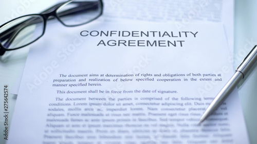 Confidentiality agreement  lying on table  pen and eyeglasses on document