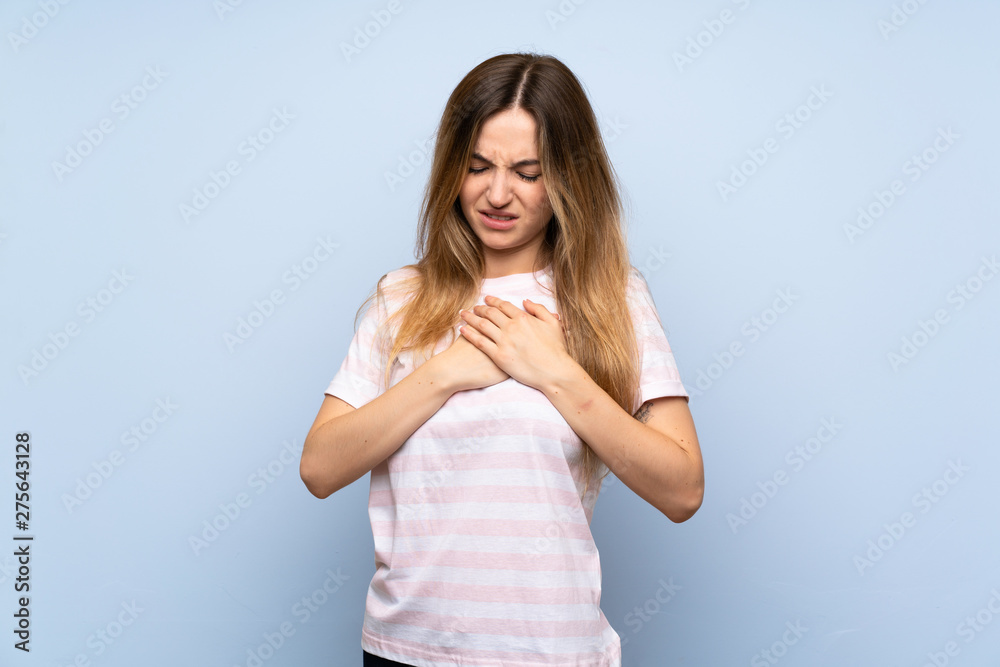 Young woman over isolated blue background having a pain in the heart Young woman over isolated blue background having a pain in the heart