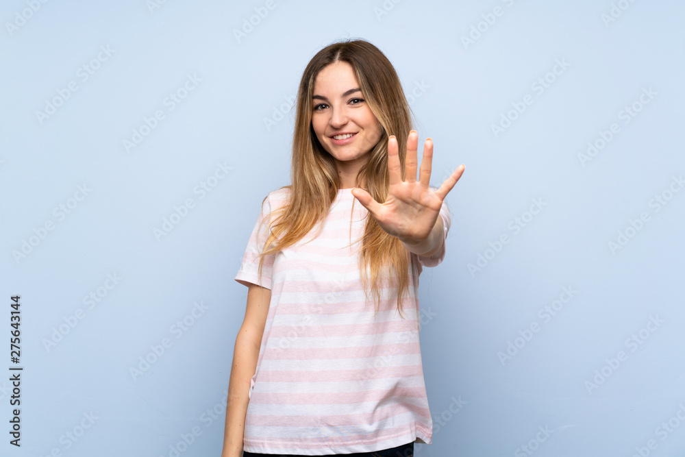 Young woman over isolated blue background counting five with fingers Young woman over isolated blue background counting five with fingers