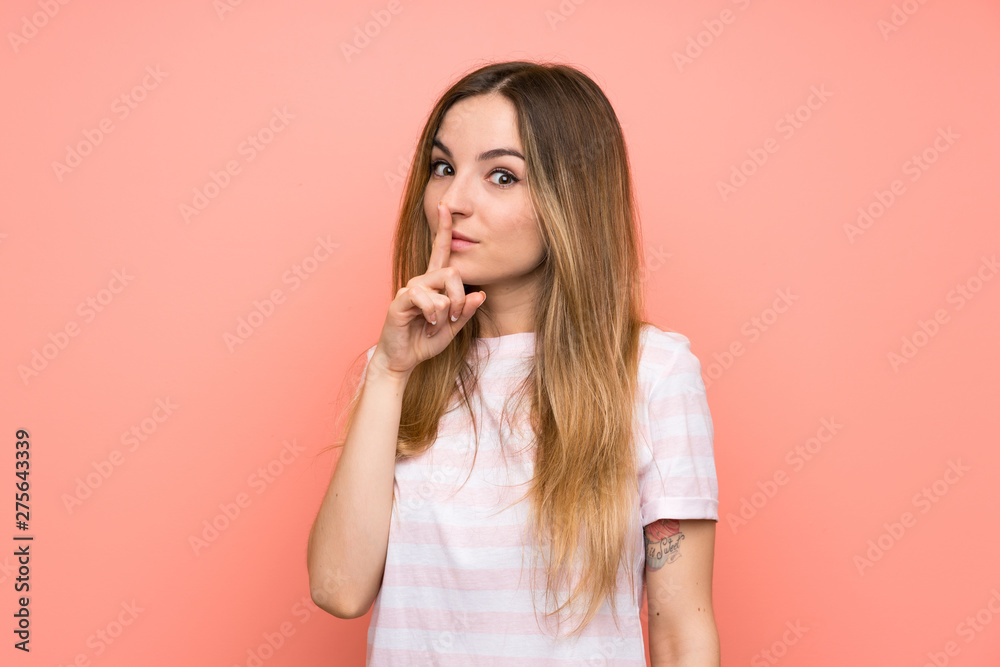 Young woman over isolated pink wall doing silence gesture Young woman over isolated pink wall doing silence gesture
