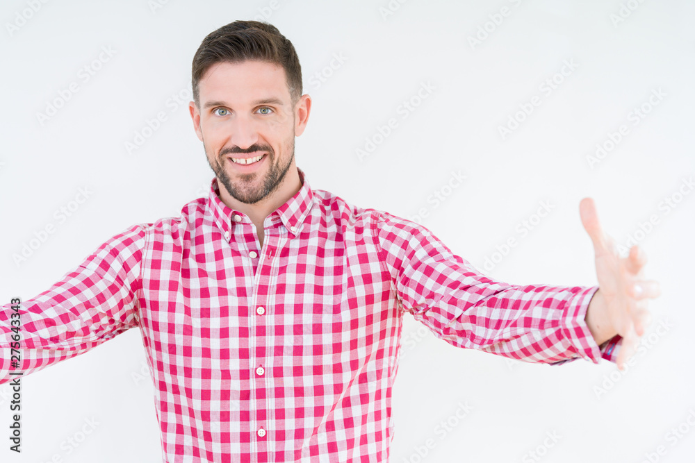 Young handsome man wearing shirt over isolated background looking at the camera smiling with open arms for hug. Cheerful expression embracing happiness. Young handsome man wearing shirt over isolated background looking at the camera smiling with open arms for hug. Cheerful expression embracing happiness.