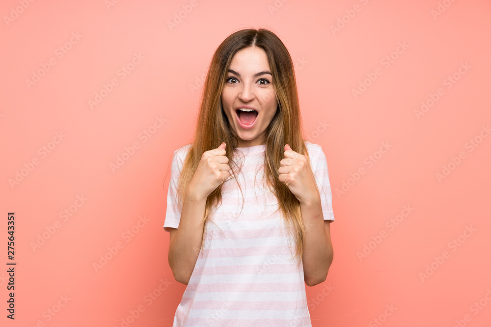 Fototapeta premium Young woman over isolated pink wall celebrating a victory