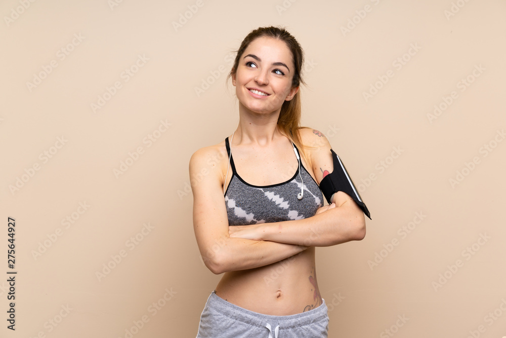 Obraz premium Young sport woman over isolated background looking up while smiling