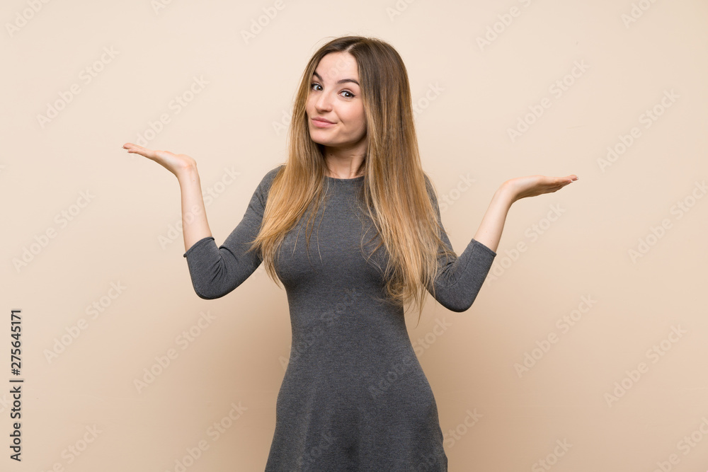 Young woman over isolated background having doubts while raising hands Young woman over isolated background having doubts while raising hands