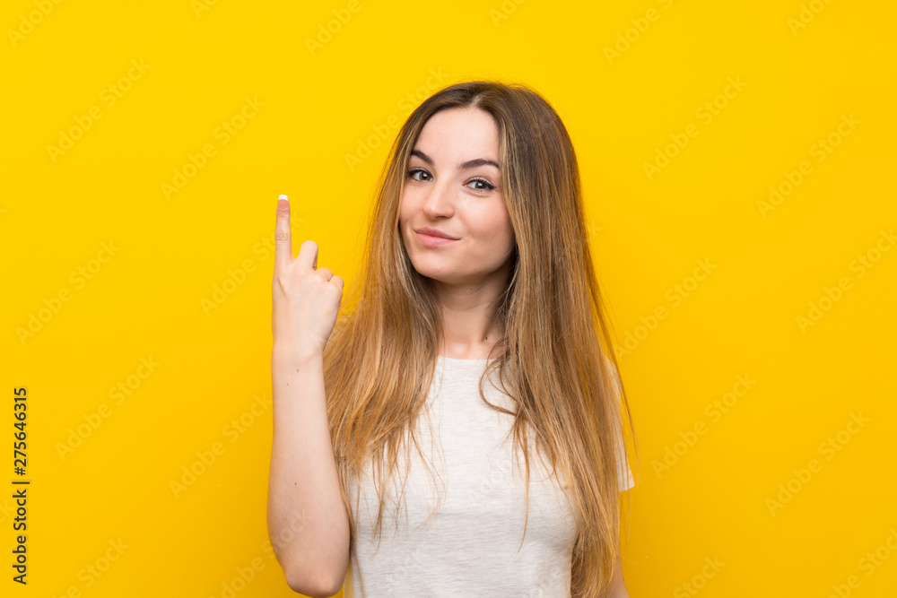 Young woman over isolated yellow wall pointing with the index finger a great idea Young woman over isolated yellow wall pointing with the index finger a great idea