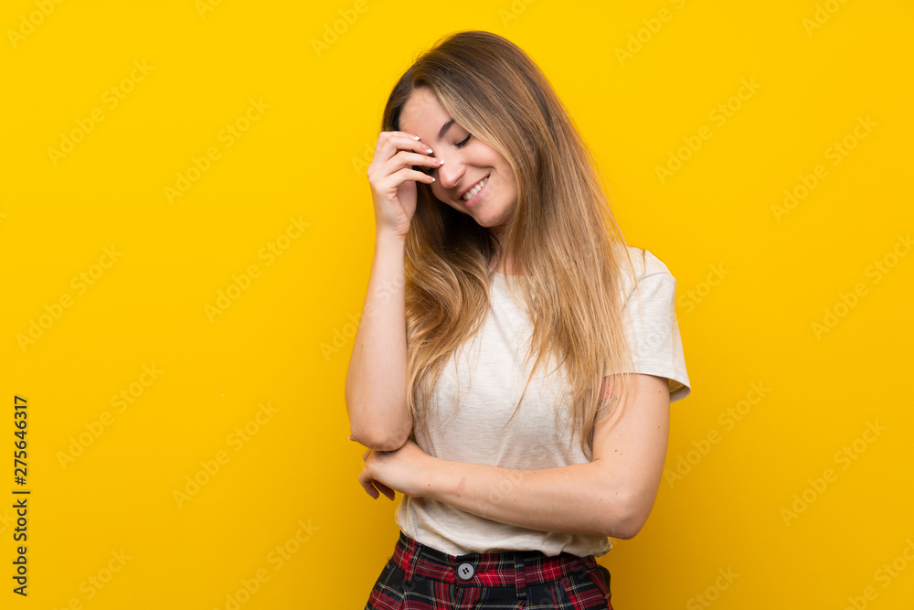 Young woman over isolated yellow wall laughing Young woman over isolated yellow wall laughing
