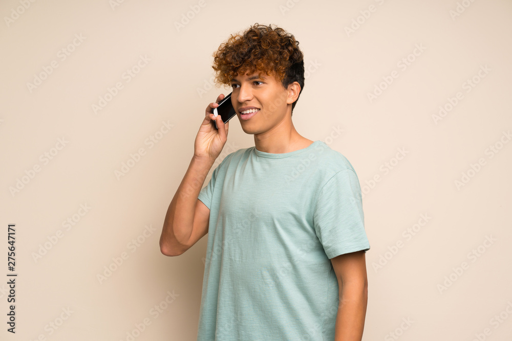 African american man with green shirt keeping a conversation with the mobile phone African american man with green shirt keeping a conversation with the mobile phone