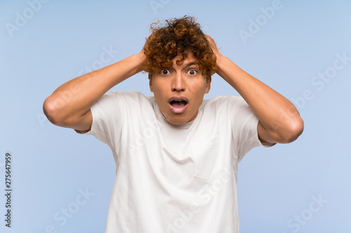 Young african american man with white shirt with surprise facial expression