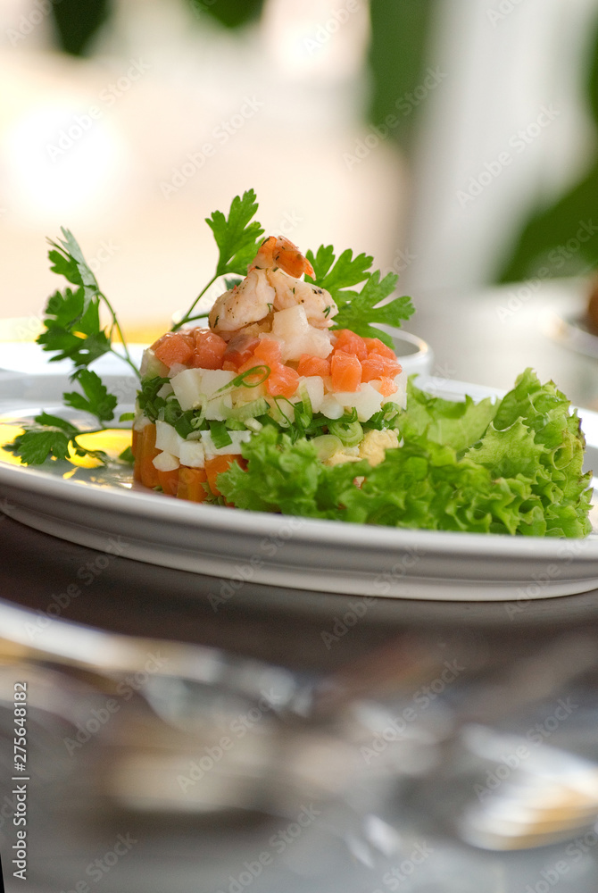 Olivier salad with shrimps, eggs and vegetables on a white plate. Depth of field Olivier salad with shrimps, eggs and vegetables on a white plate. Depth of field