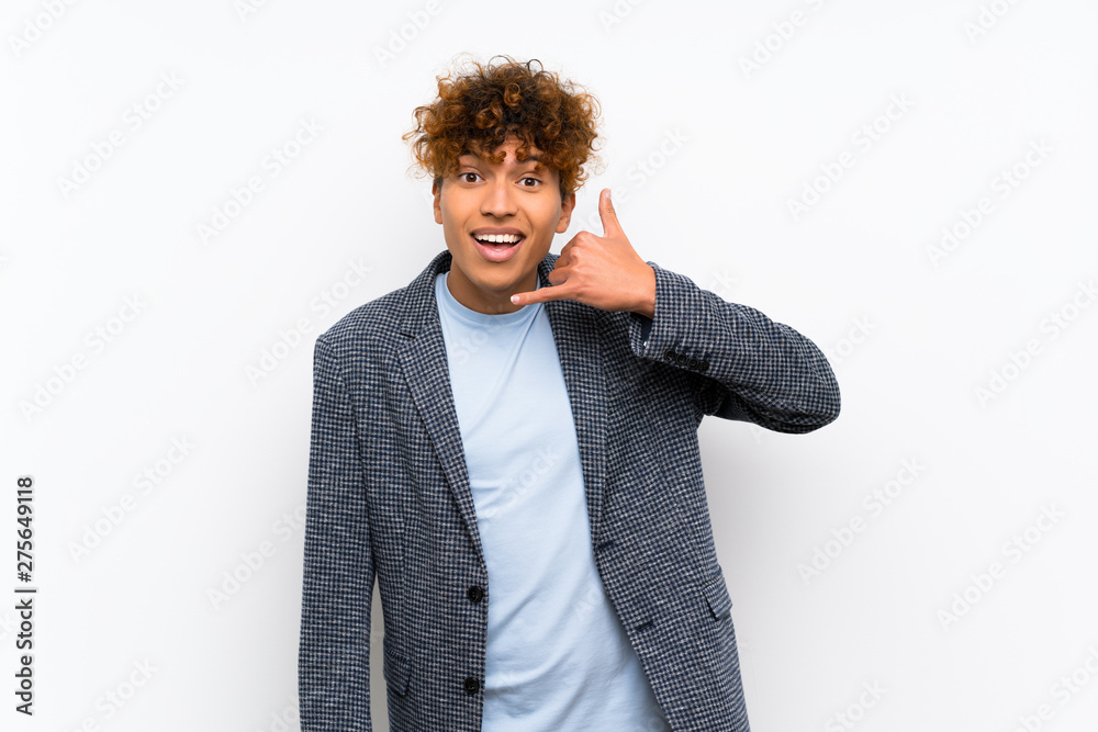 Fashion african american man over isolated white wall making phone gesture. Call me back sign Fashion african american man over isolated white wall making phone gesture. Call me back sign