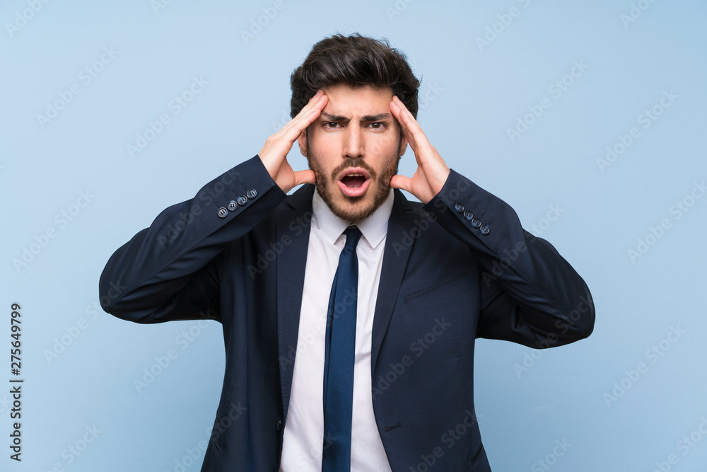 Businessman over isolated blue wall with surprise expression Businessman over isolated blue wall with surprise expression