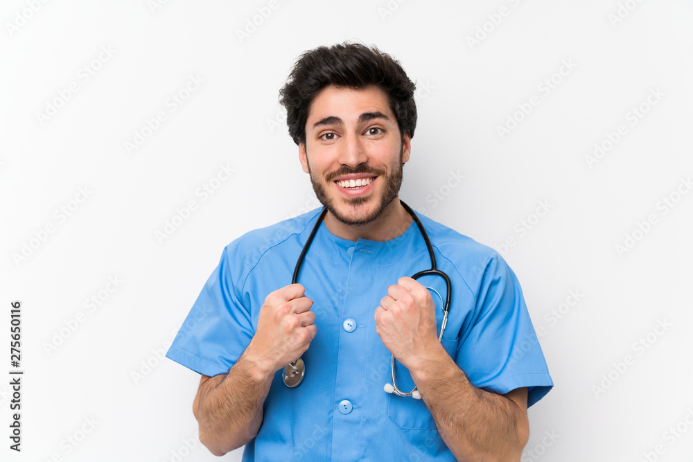 Surgeon doctor man over isolated white wall celebrating a victory Surgeon doctor man over isolated white wall celebrating a victory