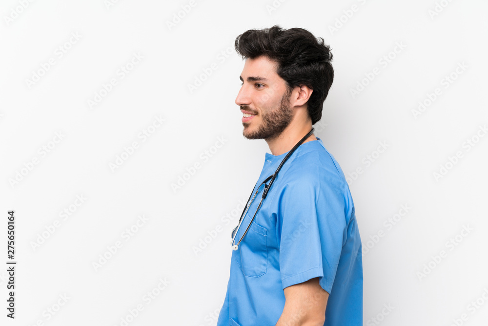 Surgeon doctor man over isolated white wall standing and looking to the side Surgeon doctor man over isolated white wall standing and looking to the side