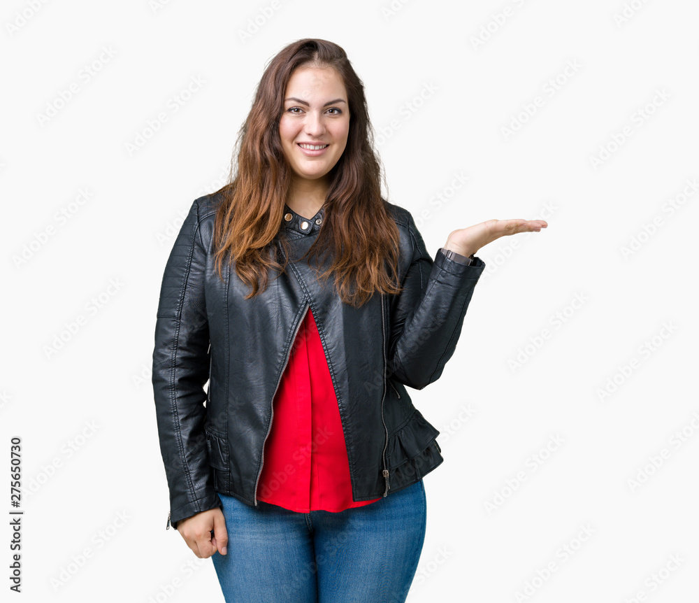 Beautiful plus size young woman wearing a fashion leather jacket over isolated background smiling cheerful presenting and pointing with palm of hand looking at the camera. Beautiful plus size young woman wearing a fashion leather jacket over isolated background smiling cheerful presenting and pointing with palm of hand looking at the camera.