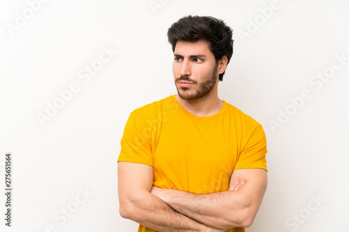 Handsome over isolated white wall standing and thinking an idea