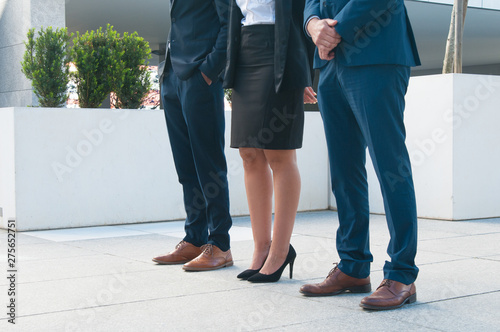 Legs of business people standing on piled porch. Close-up of unrecognizable company representative meeting guests outdoors. Welcoming business partners concept