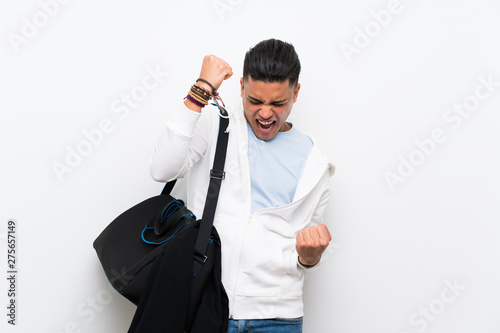 Sport man over isolated white wall celebrating a victory