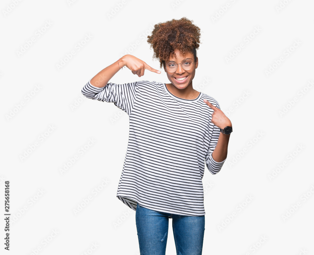 Beautiful young african american woman wearing glasses over isolated background smiling confident showing and pointing with fingers teeth and mouth. Health concept. Beautiful young african american woman wearing glasses over isolated background smiling confident showing and pointing with fingers teeth and mouth. Health concept.