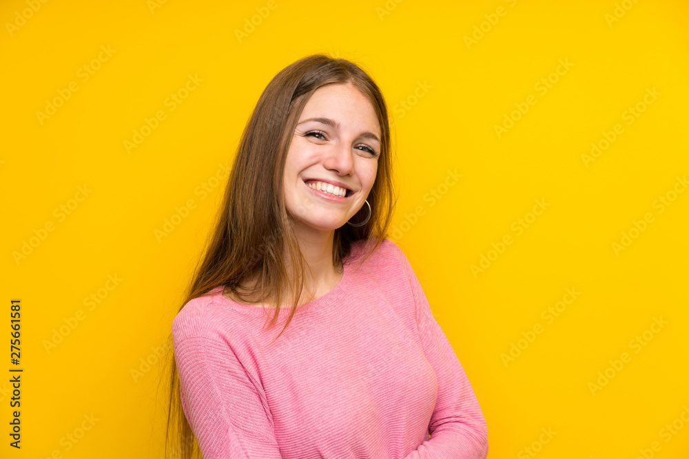 Fototapeta premium Young woman with long hair over isolated yellow wall smiling