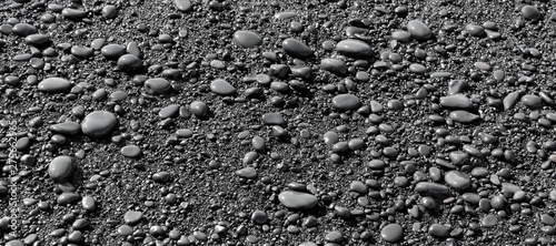 Wet black pebbles from black sand beach of Reynisfjara beach in Iceland
