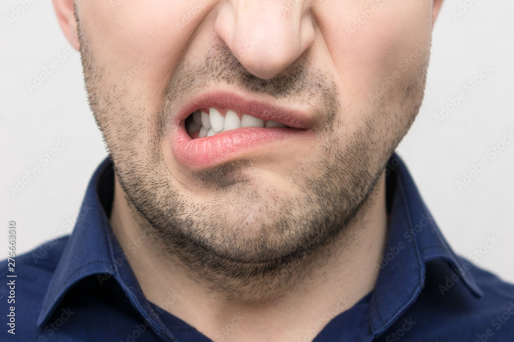 Grimace of irritation or discontent on the face of a young bearded man, close up, the concept of human emotion,emotions Grimace of irritation or discontent on the face of a young bearded man, close up, the concept of human emotion,emotions