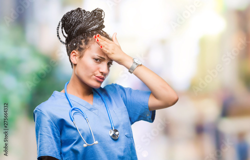 Young braided hair african american girl professional surgeon over isolated background surprised with hand on head for mistake, remember error. Forgot, bad memory concept.